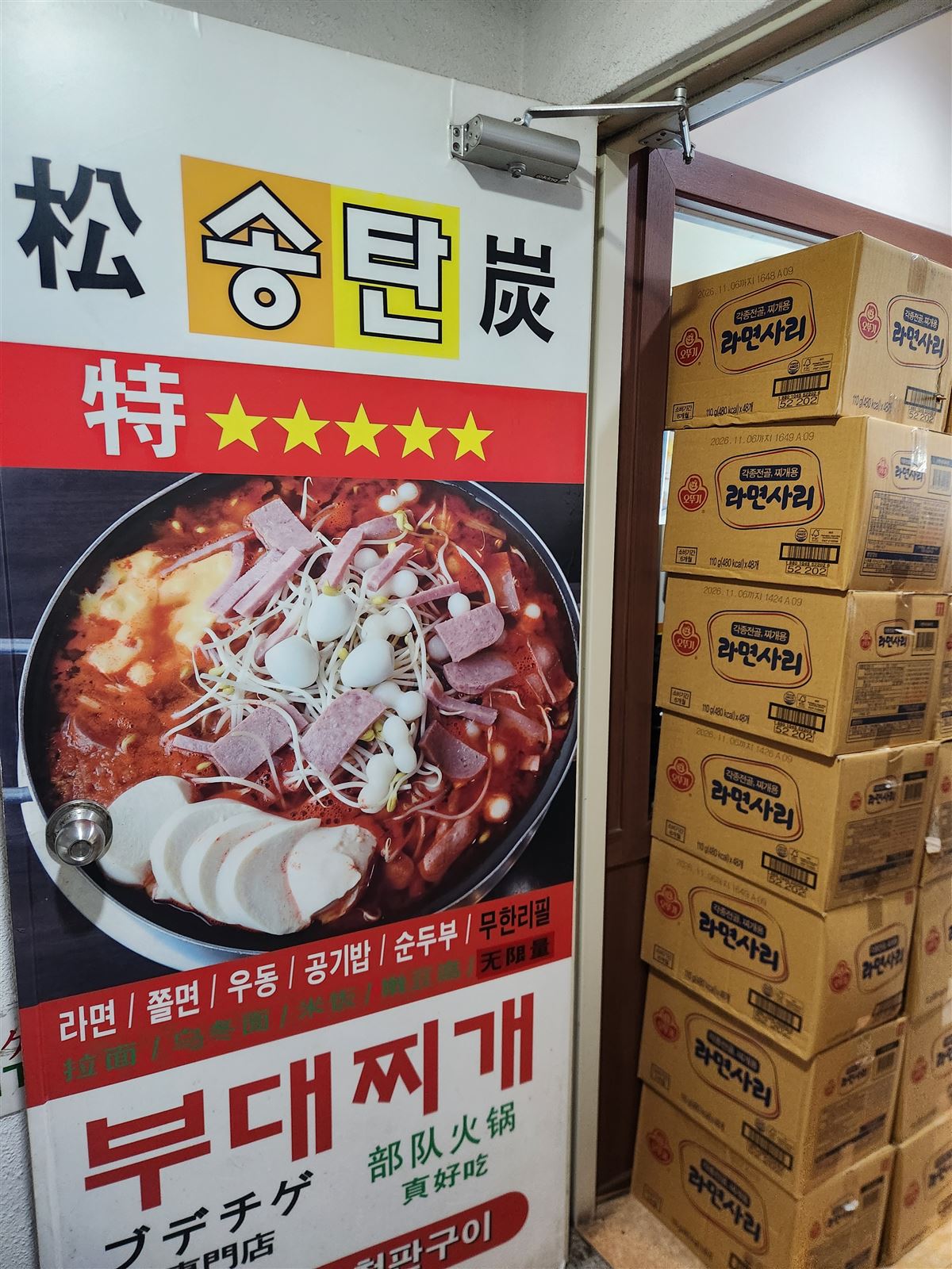 Songtan Budae Jjigae sign with the army stew photo and refill banner, Myeongdong Seoul