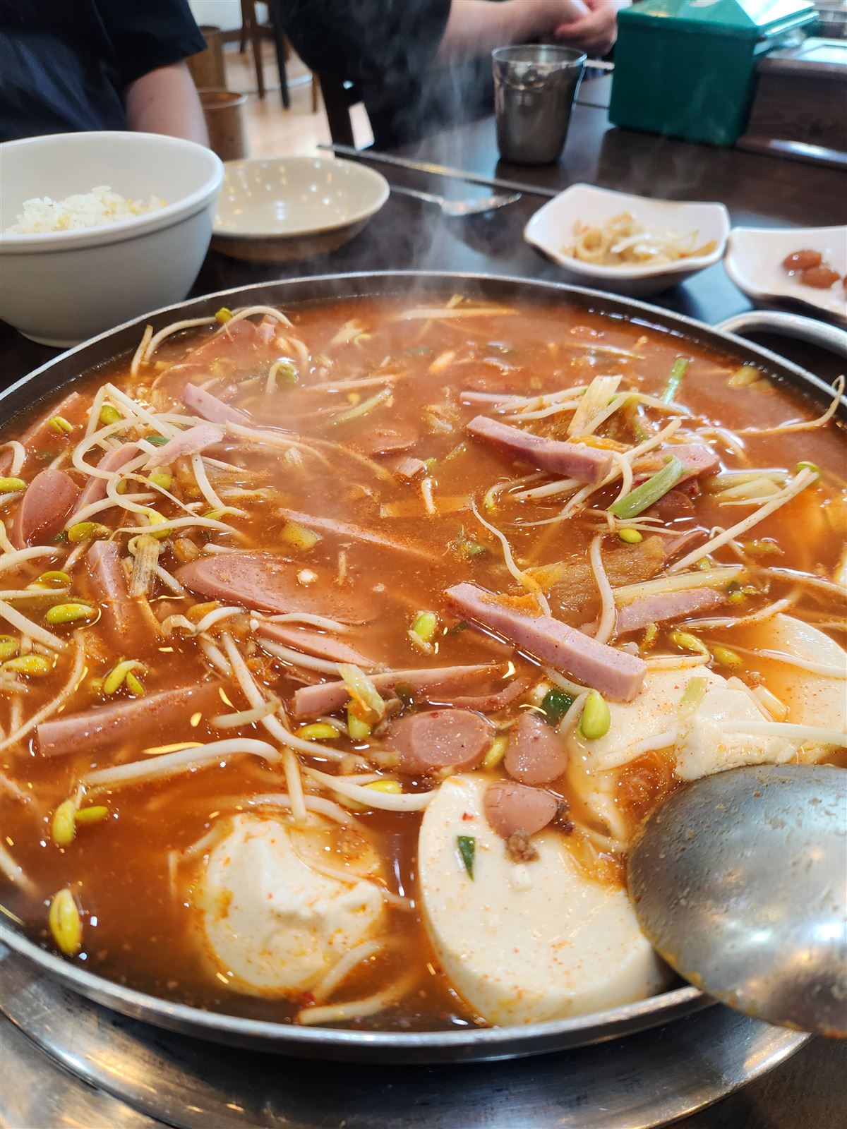 Budae jjigae with soft tofu, ham and sausage in red broth at Songtan Budae Jjigae Myeongdong