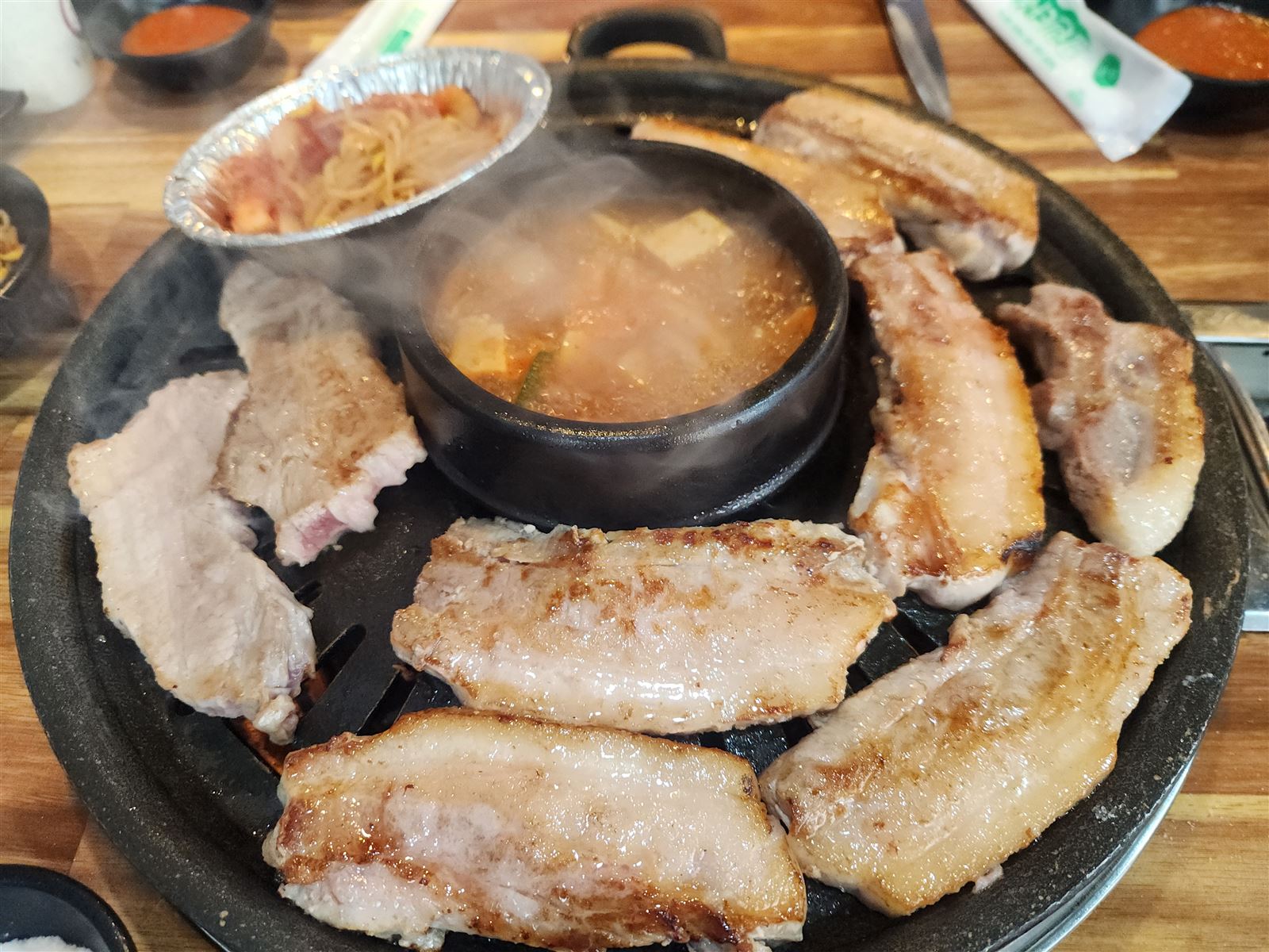 首爾明洞엉터리生肉,烤好的五花肉圍著中間咕嘟咕嘟煮著的大醬湯