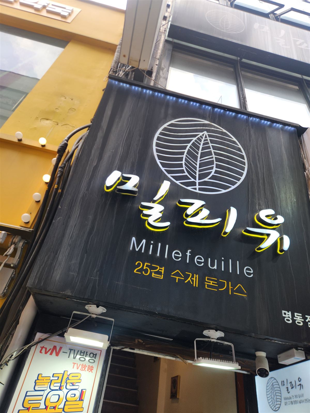 25겹 수제 돈가스·tvN 방영이 적힌 검은 밀푀유 간판, 명동