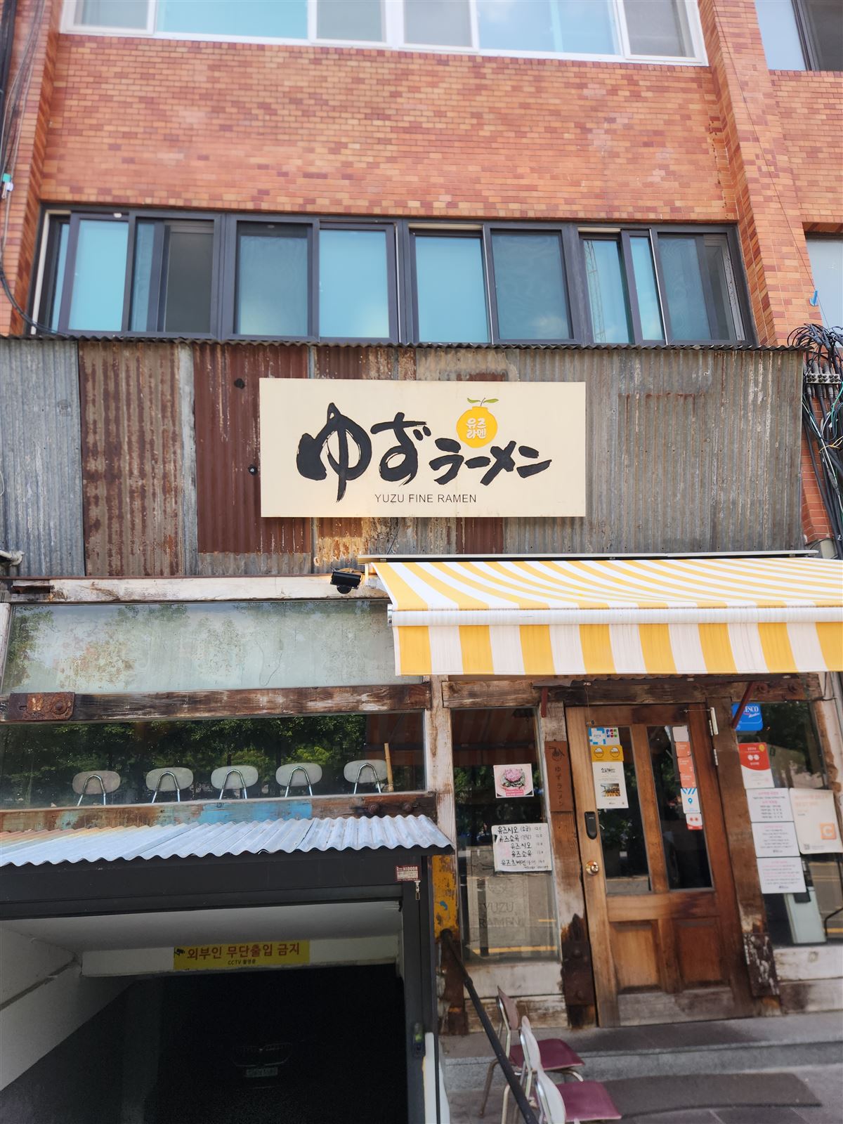 Yellow Yuzu Ramen sign on a corrugated storefront in an alley near Seoul Station